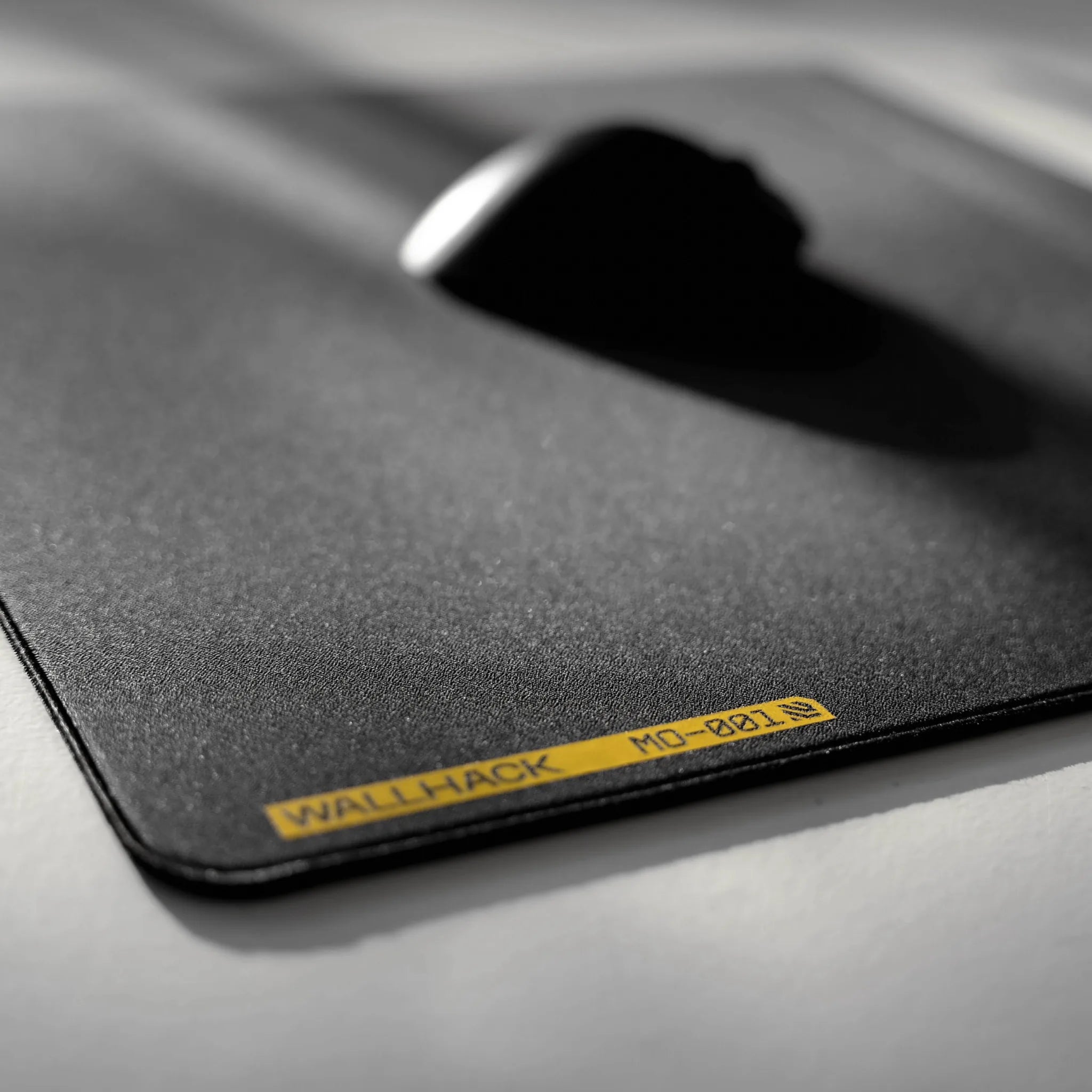 Black mouse pad with 'AJO89' branding on a gray surface